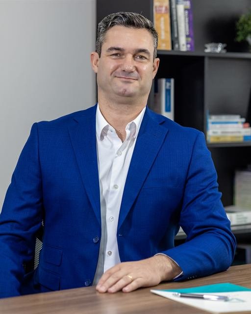 Ricardo Paschoaleto à mesa de trabalho, no escritório