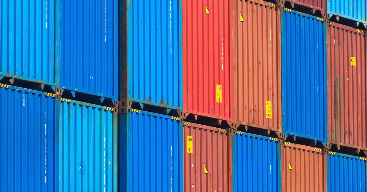 Contêineres de carga coloridos empilhados em um pátio de logística